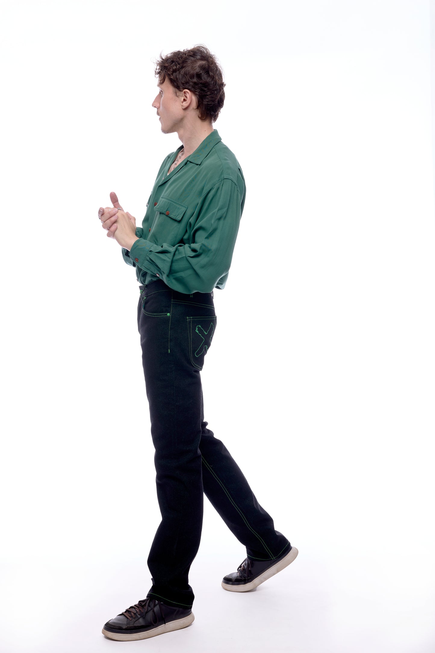 Side view of Model 1 wearing the Greatest Swordsman black+green jeans (X is visible)
